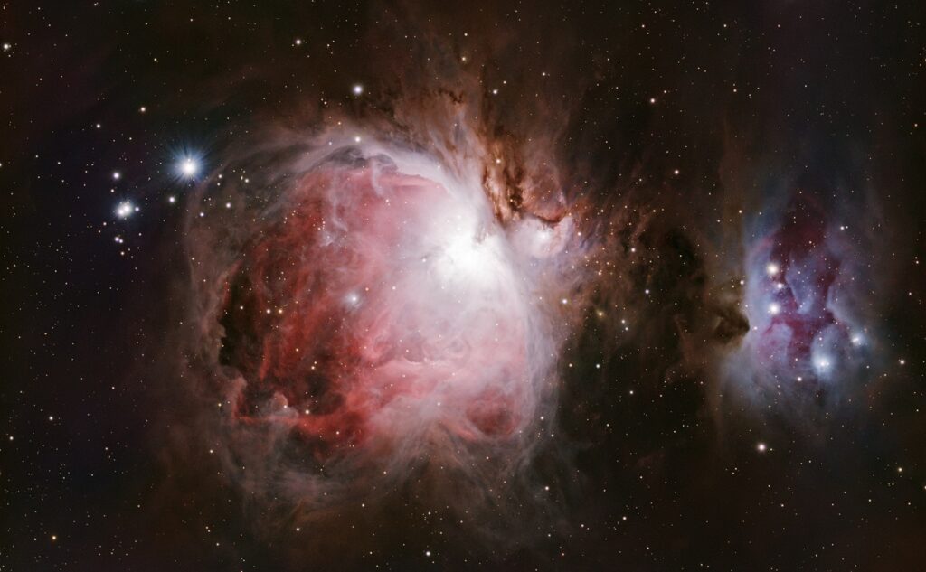 Nebulae and stars illuminate the vast expanse of space.